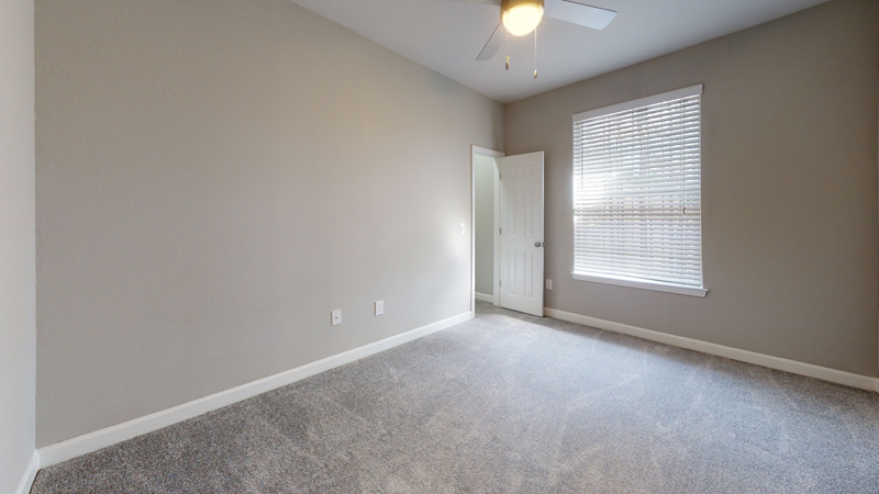 large carpeted bedroom with window