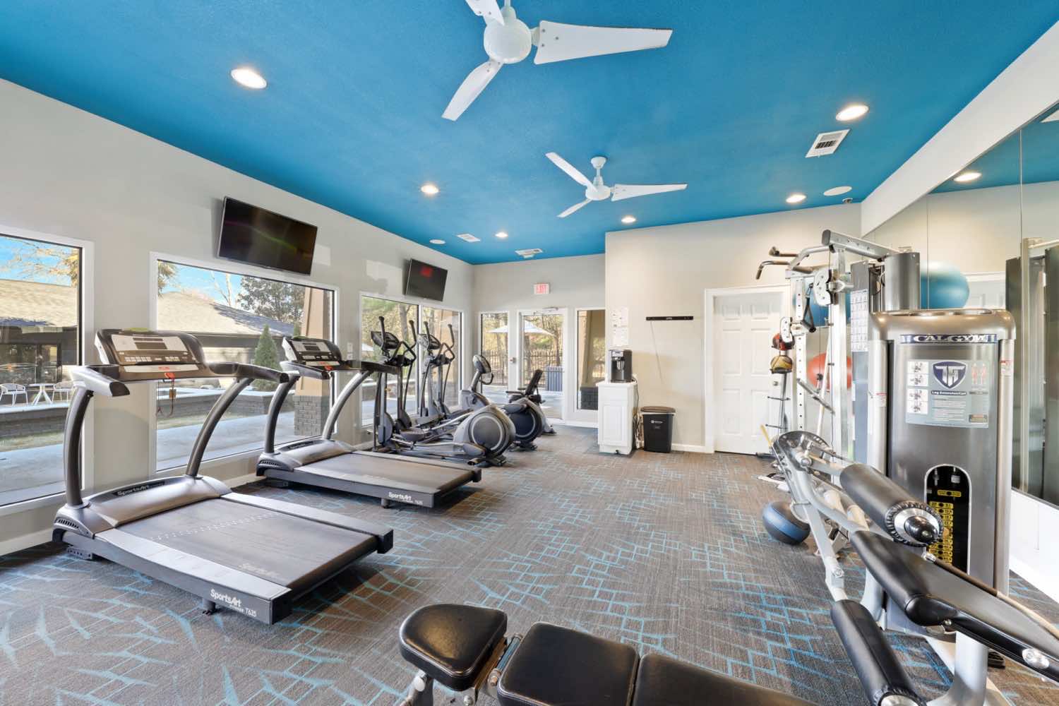 Two treadmills, two elliptical machines and a sitting bike in fitness center